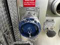 A blue valve with a chain attached to a metal surface featuring labels indicating caution and operational instructions
