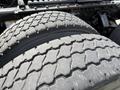 Close-up of two large truck tires with a rugged tread pattern showing wear indicating they are used and part of a heavy-duty vehicle