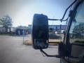 A side mirror of a 2013 Mitsubishi Fuso FE 160 truck reflecting a view of the surroundings