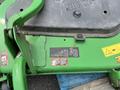 A 2014 John Deere 1585 Terrain Cut mower showing the underside with safety labels and operational details