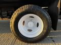 Close-up of a black tire mounted on a white wheel with the text Open Country A visible on the sidewall