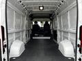 Empty interior of a 2021 RAM Promaster showing two front seats and a spacious cargo area with a flat floor and walls designed for storage and customization