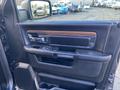 The interior door panel of a 2017 RAM 1500 featuring wood accents power window controls and a sleek design