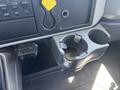 Interior of a 2018 International DuraStar featuring a gray cup holder with a cylindrical insert and a black panel with buttons and a yellow lever