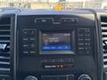 Dashboard of a 2015 Ford F-150 displaying a digital radio interface with station information and climate control settings