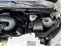 The engine compartment of a 2015 Ford Transit showing various engine components including hoses caps and the battery compartment