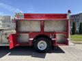 A red 1994 Volvo FE 42 fire truck with compartments and a light on top standing on a concrete surface