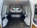 Interior view of a 2010 Ford Transit Connect showing a spacious empty cargo area with metal and plastic walls and a rubber floor mat