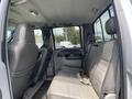 Interior view of the back seat of a 2007 Ford F-350 SD featuring two leather seats with a central armrest and seat belts visible