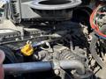 Close-up of a 2022 Freightliner Cascadia engine with various hoses and components visible along with a yellow cap on the engine oil fill