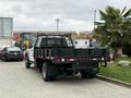 A 2020 Ford F-550 truck with a flatbed and black grill visible from the rear