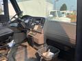 Interior view of a 2007 Freightliner B2 featuring a steering wheel dashboard with controls and a gear shift with a trash bin on the floor