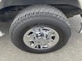 Close-up of a shiny chrome wheel attached to a 2013 Chevrolet Express with a textured black tire featuring the brand name Bravo A/T