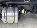 A silver fuel tank with attached pipes and a filter beneath a 2013 Kenworth T370 truck