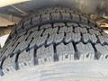 Close-up of a rugged tire with deep treads designed for traction on a 2015 Ford F-450 SD vehicle