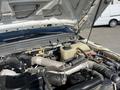 A 2015 Ford F-450 SD with the hood open revealing the engine compartment and various engine components including hoses and a coolant reservoir