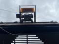 A 2008 Mitsubishi Fuso FE180 with a mounted light bar on top and equipment visible on the vehicle's surface