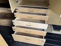 The image shows multiple open wooden drawers in a van, revealing a wooden interior with several storage compartments