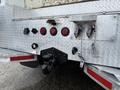 A close-up of the rear of a 2005 Freightliner M2 106 featuring metal fixtures lights and towing equipment on a diamond plate surface