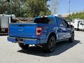 A blue 2021 Ford F-150 truck with a modern design features a prominent rear tailgate and stylish wheels