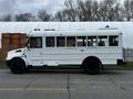 A white 2013 International 4200 school bus with multiple windows