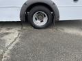 A 2017 Chevrolet Express with a flat tire on the front passenger side showing the wheel and rim