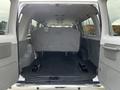 Interior view of a 2014 Ford Econoline showing a spacious cargo area with gray upholstery and a single bench seat facing forward