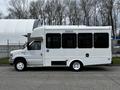 A white 2016 Ford Econoline van with large tinted windows and a disability access symbol on the side