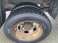 Close-up of a Continental tire mounted on a rusted wheel of a 2008 Dodge Ram 5500 showcasing deep tread pattern and worn appearance