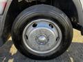 Close-up of a silver wheel with lug nuts mounted on a black tire from a 2014 Mitsubishi Fuso FE