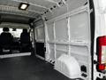 The interior of a 2021 RAM Promaster van showing metal walls and floor with no cargo, featuring two black seats in the front and a spacious, empty cargo area