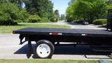 A 2006 Ford F-650 with a flatbed and single rear wheel is parked on a road