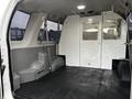 Interior of a 2011 Ford Econoline van with a spacious cargo area featuring a flat black rubber floor and minimal partitions