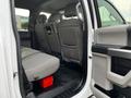 Interior view of a 2021 Ford F-550 showing the back seats with grey upholstery and a red toolbox on the floor