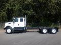 A white 2009 International 7400 truck chassis with a prominent cab and large wheels positioned on a paved surface