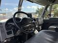 Interior view of a 2013 International 7400 truck featuring a steering wheel dashboard and seat with various controls and gauges