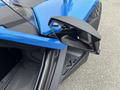 A blue 2020 Polaris Slingshot with a sleek design and a distinctive side mirror showing its modern features and sharp angles