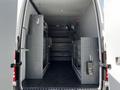 Interior of a 2017 Mercedes-Benz Sprinter van featuring gray shelving units and organizational storage on both sides