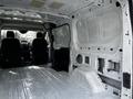 A 2018 Ford Transit van interior showing an empty cargo area with bare metal surfaces and two front seats visible in the foreground