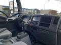 Interior view of a 2022 Isuzu NPR showing the dashboard steering wheel and gear shift with several control panels and displays