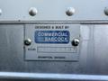 A silver metal plaque attached to a 2007 GMC W5500 cube van displaying the text "DESIGNED & BUILT BY COMMERCIAL BABCOCK" and the location "BRAMPTON ONTARIO" with a work order number