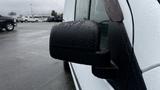 Close-up of the side mirror on a 2012 Ford Transit covered in droplets of water