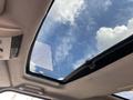 A panoramic sunroof view from inside a 2006 Land Rover LR3 showing the sky and clouds