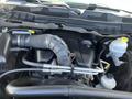 Engine compartment of a 2011 RAM 1500 featuring a large engine cover air intake and various connected hoses and fluid reservoirs