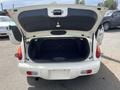 A white 2005 Chrysler PT Cruiser with an open hatchback showing the black interior of the cargo space