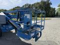 A blue 2012 Genie Z 45/25 aerial lift with a circular work platform and safety railing attached to the arm of the lift