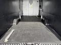 Empty cargo area of a 2021 Ford Transit with a flat floor and two wheel wells visible on either side
