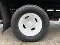 A close-up of a white wheel of a 2019 Ford Econoline showcasing a tire with a textured surface and a five-bolt rim design