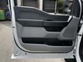 The image shows the interior door panel of a 2024 Ford F-550 featuring a sleek design with a combination of gray and black materials and a textured handle