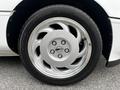 Close-up of a silver wheel from a 1992 Chevrolet Corvette featuring a distinctive five-spoke design and a Corvette logo in the center